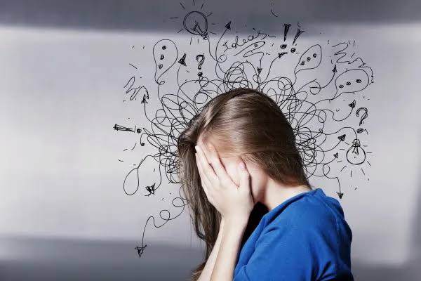 Pessoa em estado de alerta e sobrecarga mental, representando ansiedade em um contexto de vida acelerada.